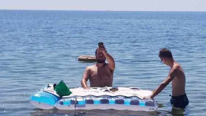 Soluția anti-caniculă a unui preot a ținut slujba în apă îmbrăcat în slipi și cu salteaua drept altar