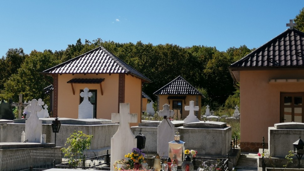 Cimitirul din România care are căsuțe în loc de cavouri. Acoperișuri moderne uși de termopan și perdeluțe la ferestre